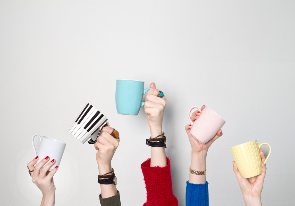 different hands holding coffee mugs